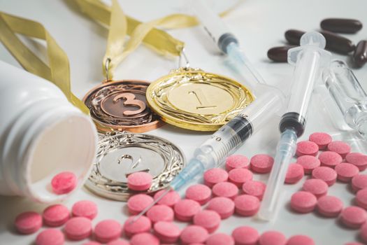Pile of drugs in pills and injections and sports medals. Concepts of drug usage and doping in sport for best performance