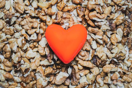 Heart shape on a heap of walnuts. Food for the heart's health, healthy eating concept.