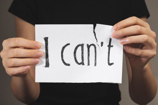 Hands tearing out negation of the "i can not" sign. Motivational concept of believing in yourself and overriding problems and emotional difficulties