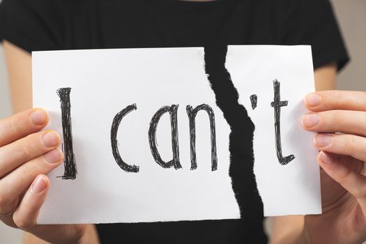 Hands tearing out negation of the "i can not" sign. Motivational concept of believing in yourself and overriding problems and emotional difficulties