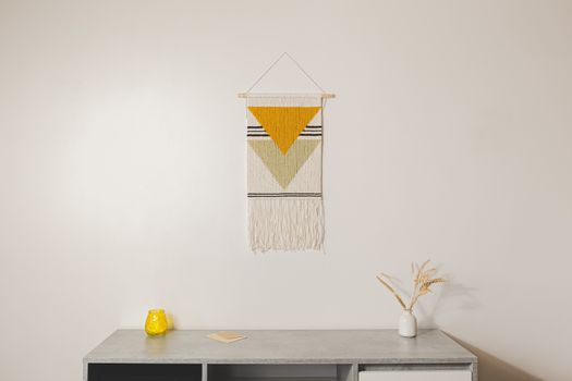 Home decor, living room design. Handmade macrame wallhanging in modern sparse indoor set