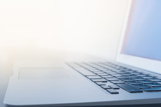 Surface of a portable computer against the bright light. Concept of well lit and bright workplace, using computer at daylight