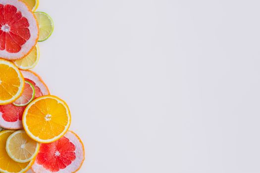 Fresh juicy citrus fruit background with copy space. Healthy fresh raw food, lemonade indgredients: orange, lime, grapefruit and lemon slices