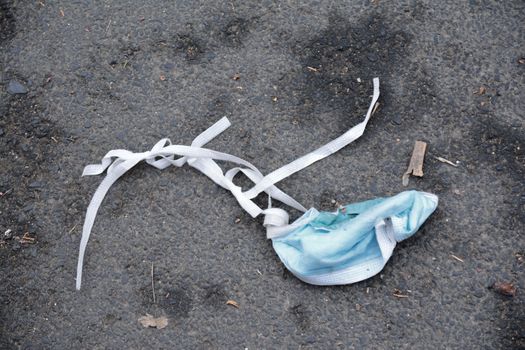 A discarded surgical face mask lying in the street