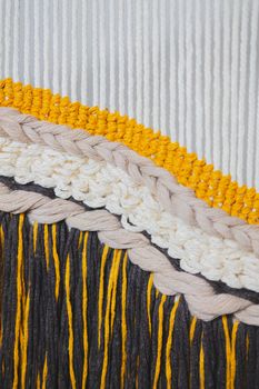 Details of a macrame handcrafted decor. Texture of hand-knitted crochery, close-up view