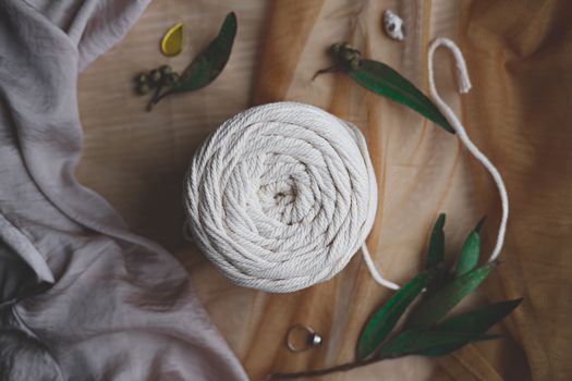 Roll of macrame rope, top view. White thread in beautiful pastel backdrop, flat lay image