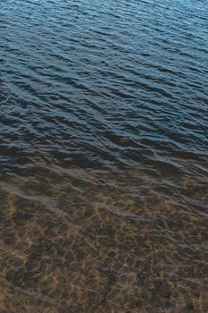 Texture of water surface against the sun. Natural backdrop, textured background