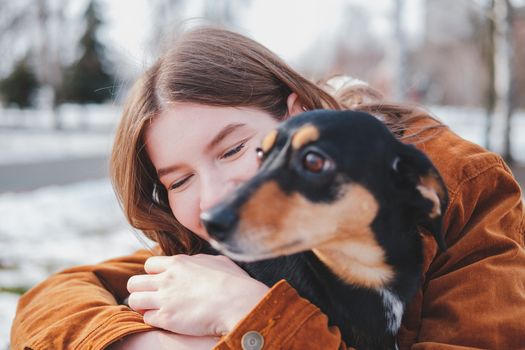 Human being happy with a dog. Loving pets concept: happy young woman hugs her dachshund at a walk, selective focus