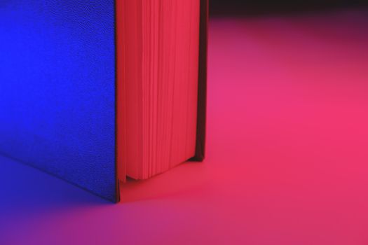 Detailed view of a book in vibrant blue and red colors. Vivid neon gradients, abstract background image
