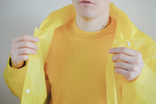 Male person in yellow t-shirt and raincoat. Man body parts, vivid yellow colors