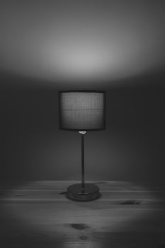 Electric lamp on the table top, monochrome low key. Cozy bedroom light at night, minimalistic and sparse image