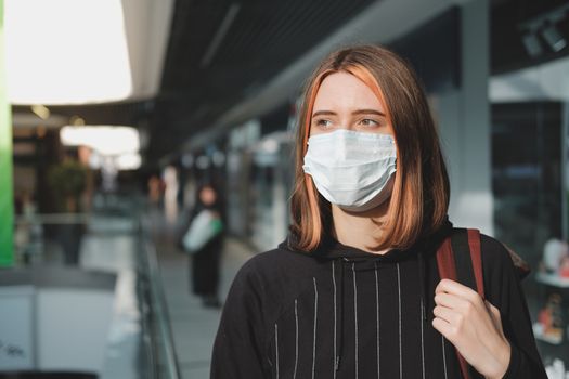 Woman in a protective face mask at a shopping mall. Coronavirus, COVID-19 spread prevention concept, responsible social behaviour of a citizen