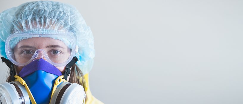 Portrait of a healthcare worker woman in protective glasses and respirator mask. Medical staff, hospital doctor or scientist developing anti virus vaccine portrait with copy space
