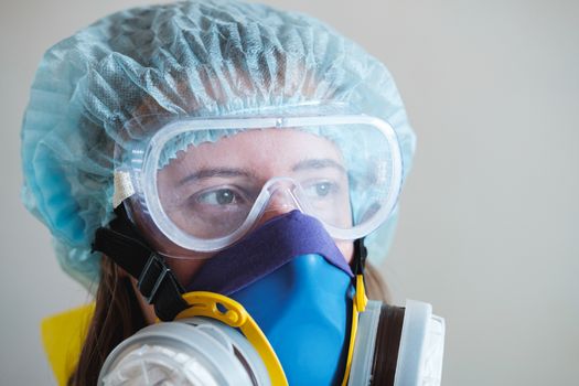 Portrait of a healthcare worker woman in protective glasses and respirator mask. Medical staff, hospital doctor or scientist developing anti virus vaccine.