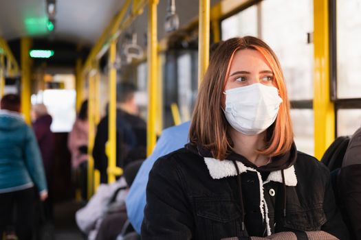 Young adult commutes in a protective face mask. Coronavirus, COVID-19 spread prevention concept, responsible social behaviour of a citizen