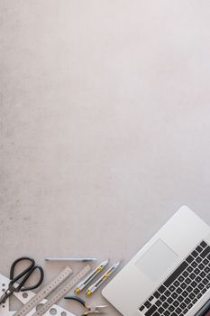 Engineering or industrial designer work place, top view with copy space. Flat lay with laptop computer, scissors, rulers and knifes with grunge backdrop