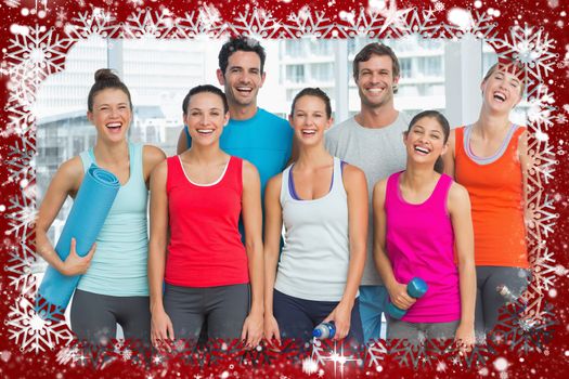 Portrait of fit people smiling in exercise room against snow