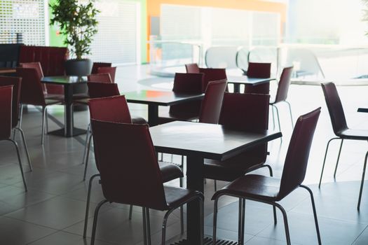 Empty chairs and tables at a food court in shopping mall. Concept of quarantine lockdown, closed business and catering business decline