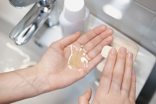 Cleaning hands with sanitizer in bathroom. Concept of self protection and hygiene in epidemic conditions