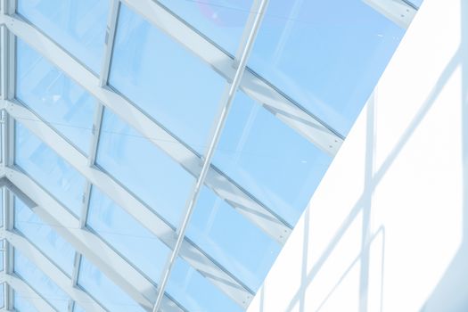 Clean roof windows and blue sky. Element of a modern glass roof of a shopping mall or airport, abstract image