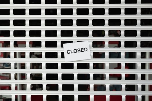 The sign "closed" on roller blinds of a shop. Concept of retailer stores and shops shut down due to quarantine