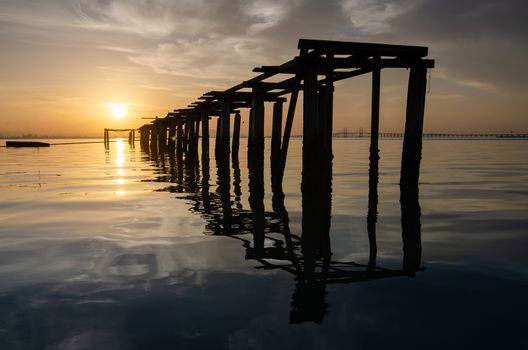 Broken bridge in morning with dramatic sunrise at Jelutong, Penang. Background is Penang Bridge.