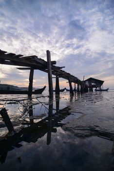 Wooden bridge at Jelutong, Penang fisherman hut dove jetty during low tide in morning.