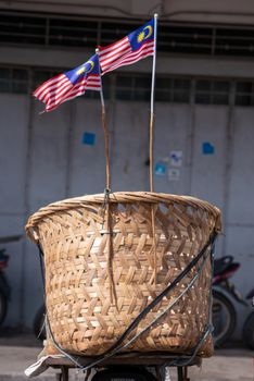 Two Malaysia flags hang at basket at street.