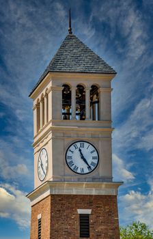 A new brick and stucco clock tower under clear blue sky