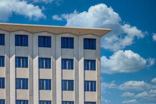 A white stone condo or apartment building under clear blue skies