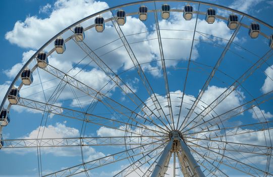 A modern white Ferris wheel against brilliant blue sky