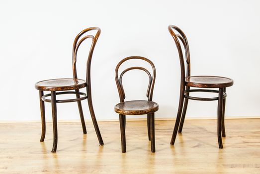 two large and one childs chair in an empty room UK