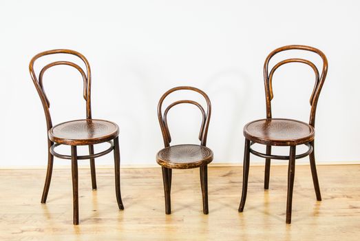 two large and one childs chair in an empty room UK