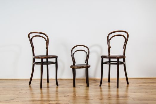 two large and one childs chair in an empty room UK
