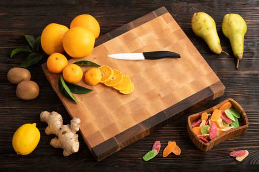 Still life with fruit. Sliced orange and other fruits on a wooden cutting board