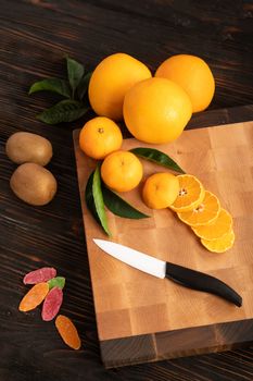Still life with fruit. Sliced orange and other fruits on a wooden cutting board