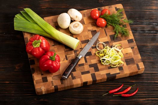 Knife vegetables and spices on a wooden cutting board