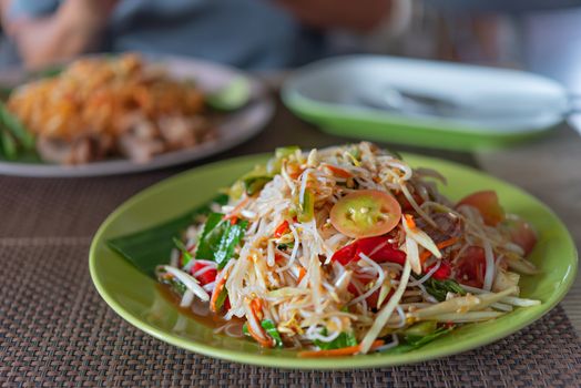 Traditional thai cuisine spicy green papaya salad with rice vermicelli