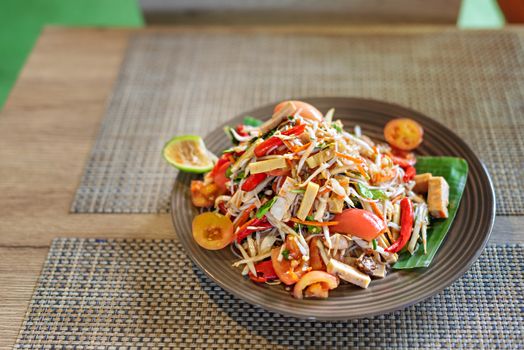 Traditional thai cuisine spicy green papaya salad with rice vermicelli