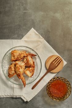 top view of stuffed chicken wings on dish served with chili sauce