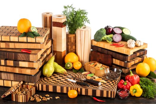 Still life with fruits, vegetables, nuts and candied fruits with cutting boards on a white background.