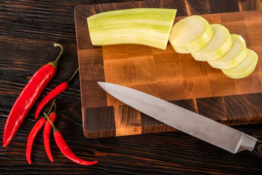 Knife vegetables and spices on a wooden cutting board