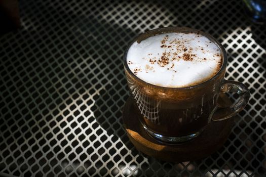 Cup of hot cappuccino coffee on steel table