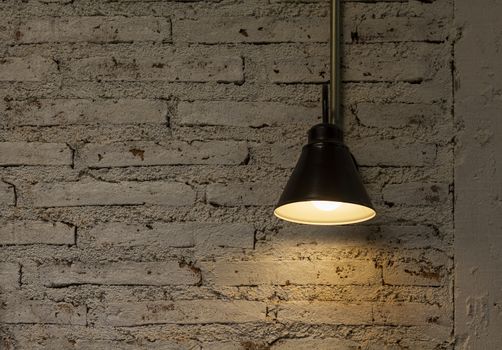 Vintage hang light bulb lamp on brick wall background