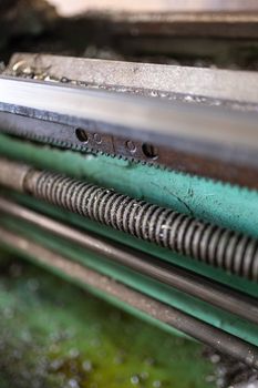 A part of the old lathe machine is painted green. Lathe for metal processing. Screw turning machine produced in 1963