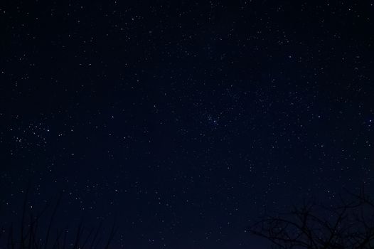 Long exposure night photo of a bright stars. A lot of stars with constellations. Far from the city. Night landscape.