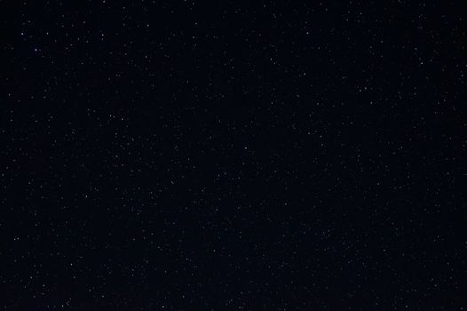 Long exposure night photo of a bright stars. A lot of stars with constellations. Far from the city. Night landscape.