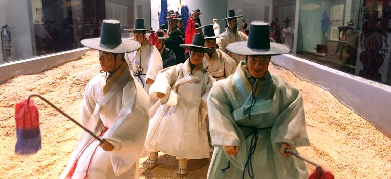 A replica of a traditional wedding procession in ancient Korea with lamps and traditional clothing as well.