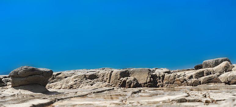 Panoramic rocky shoreline template with blue copy space
