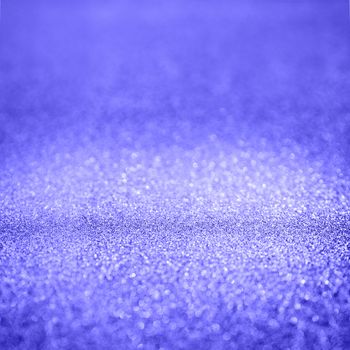 Violet abstract background with shiny glitter. Purple festive sparkling macro texture. Holiday backdrop with copy space.
